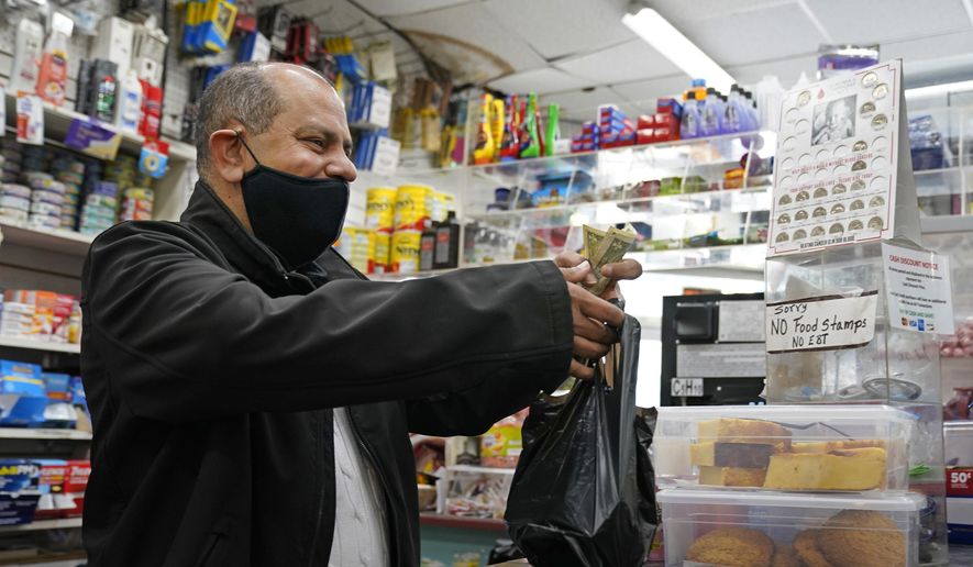 Bodega owner Francisco Marte assists a customer, Wednesday, Feb. 10, 2021, at his store in the Bronx borough of New York. Marte heads up the Bodega and Small Business Group, which represents bodegas in New York. (AP Photo/Kathy Willens)
