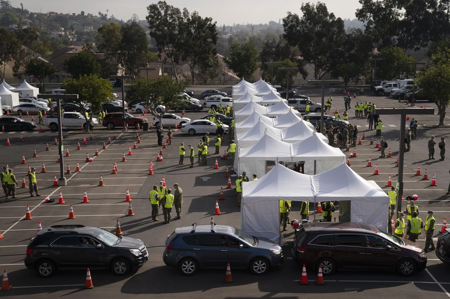 Motorists wait to get their COVID-19 vaccine at a federally-run vaccination site set up on the campus of California State University of Los Angeles in Los Angeles, Calif., Tuesday, Feb. 16, 2021. (AP Photo/Jae C. Hong)