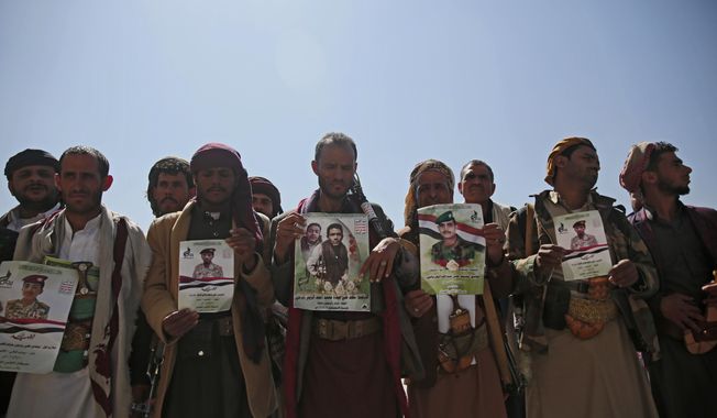 Houthis rebels hold posters of their relatives during a funeral procession for Houthis who who were killed in recent fighting with forces of Yemen&#x27;s Saudi-backed internationally recognized government, in Sanaa, Yemen, Tuesday, Feb. 16, 2021. (AP Photo/Hani Mohammed)