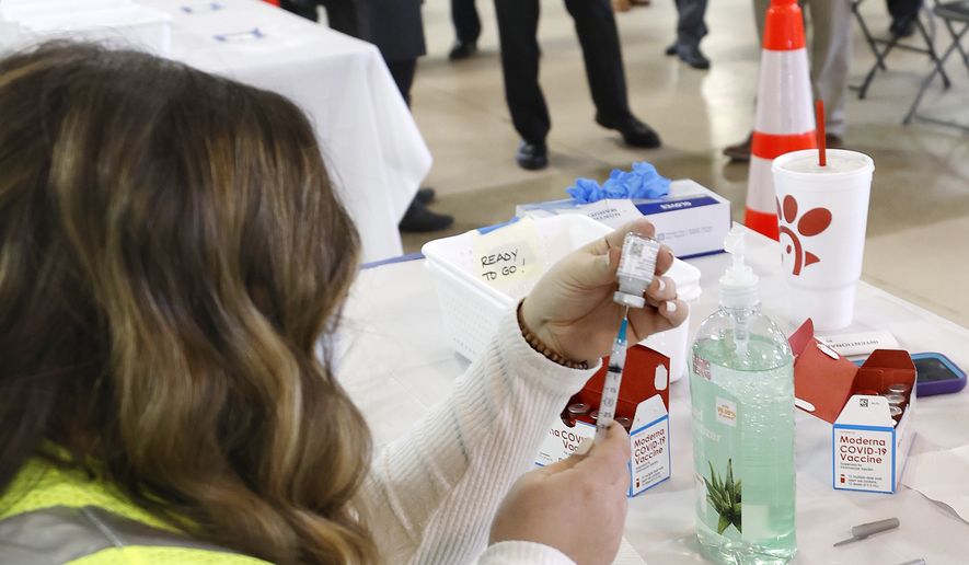 Ashleigh Trobaugh, an RN at Godwin High School, draws the second Moderna vaccine that is being given to people at the Richmond Raceway Complex in Richmond, Va., Wednesday, Feb. 17, 2021. Sen. Mark Warner was touring the operation. (Alexa Welch Edlund/Richmond Times-Dispatch via AP)