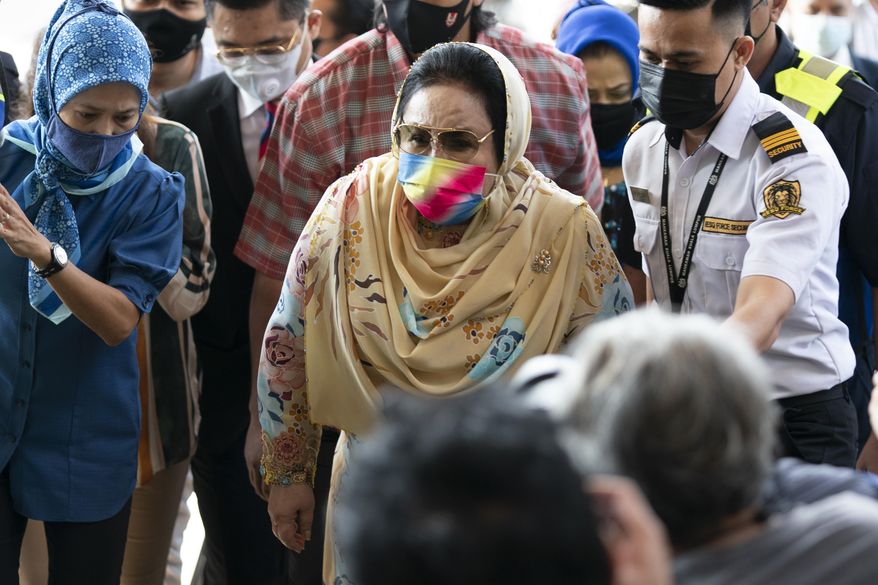 Rosmah Mansor, wife of former Malaysian Prime Minister Najib Razak, wearing a face mask arrives at Kuala Lumpur High Court in Kuala Lumpur, Malaysia, Thursday, Feb. 18, 2021. The court Thursday ordered Rosmah to enter her defense in a corruption trial linked to a 1.25 billion ringgit ($310 million) solar energy project. (AP Photo/Vincent Thian)