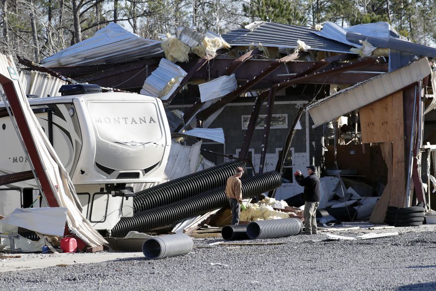 Owner Richard Dobkin, right, photographs the damage at Ocean Ridge Storage Solutions in Brunswick County, N.C. near the town of Sunset Beach, Wednesday, Feb. 17, 2021. Officials say a ferocious tornado struck shortly before midnight Monday just inland from the barrier island of Ocean Isle Beach.(AP Photo/Chris Seward)