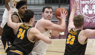 Loyola Chicago&#39;s Cameron Krutwig, center, looks to pass as Valparaiso&#39;s Jacob Ognacevic (34) and Ben Krikke defend during the second half of an NCAA college basketball game Wednesday, Feb. 17, 2021, in Chicago. Loyola Chicago won 54-52. (AP Photo/Charles Rex Arbogast)