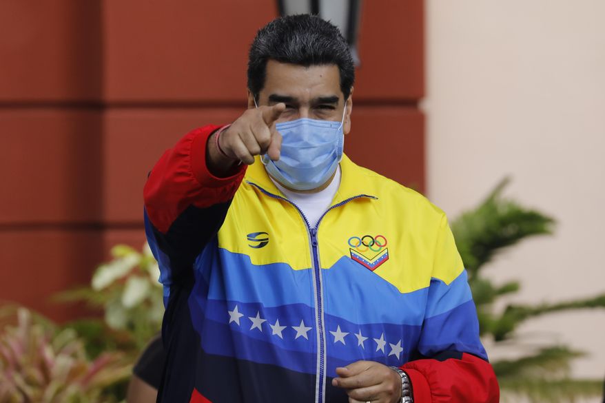 Venezuelan President Nicolas Maduro points to supporters during an event marking Youth Day at Miraflores presidential palace in Caracas, Venezuela, Friday, Feb. 12, 2021, amid the COVID-19 pandemic. The annual holiday commemorates young people who accompanied heroes in the battle for Venezuela&#39;s independence. (AP Photo/Ariana Cubillos)