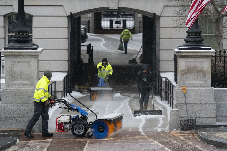 Workers from the National Park Service clear snow and ice outside the Eisenhower Executive Office building on the White House campus, Thursday, Feb. 18, 2021, in Washington. (AP Photo/Evan Vucci)