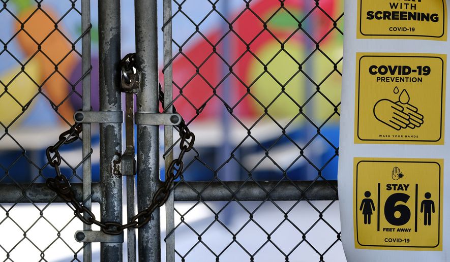 In this July 13, 2020, file photo, a gate is locked at the closed Ranchito Elementary School in the San Fernando Valley section of Los Angeles. After weeks of tense negotiations, California legislators agreed Thursday, Feb. 18, 2021, on a $6.5 billion proposal aimed at getting students back in classrooms this spring following months of closures because of the pandemic. (AP Photo/Richard Vogel, File)