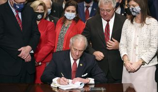 South Carolina Gov. Henry McMaster signs into law a bill banning almost all abortions in the state Thursday, Feb. 18, 2021, in Columbia, S.C. On the same day, Planned Parenthood filed a federal lawsuit to stop the measure from going into effect.  The state House approved the “South Carolina Fetal Heartbeat and Protection from Abortion Act” on a 79-35 vote Wednesday and gave it a final procedural vote Thursday before sending it to McMaster.  (AP Photo/Jeffrey Collins)