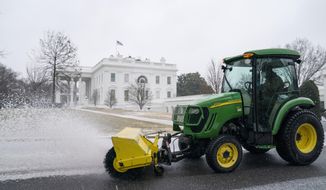 Workers from the National Park Service clear snow and ice at the White House, Thursday, Feb. 18, 2021, in Washington. (AP Photo/Evan Vucci)