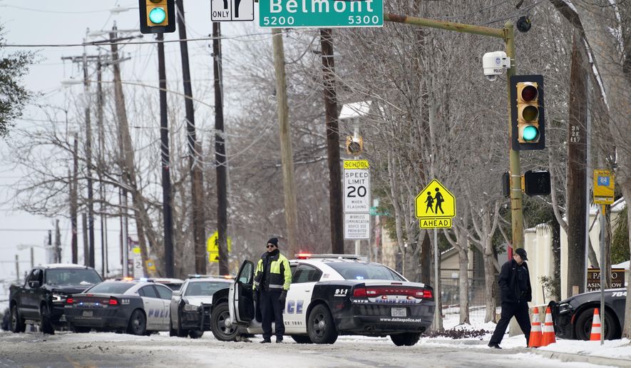 A Dallas police presence is seen at the street intersection of Belmont and Henderson in a neighborhood where earlier in the day two other officers were shot responding to an emergency call in Dallas, Thursday, Feb. 18, 2021. (AP Photo/Tony Gutierrez)
