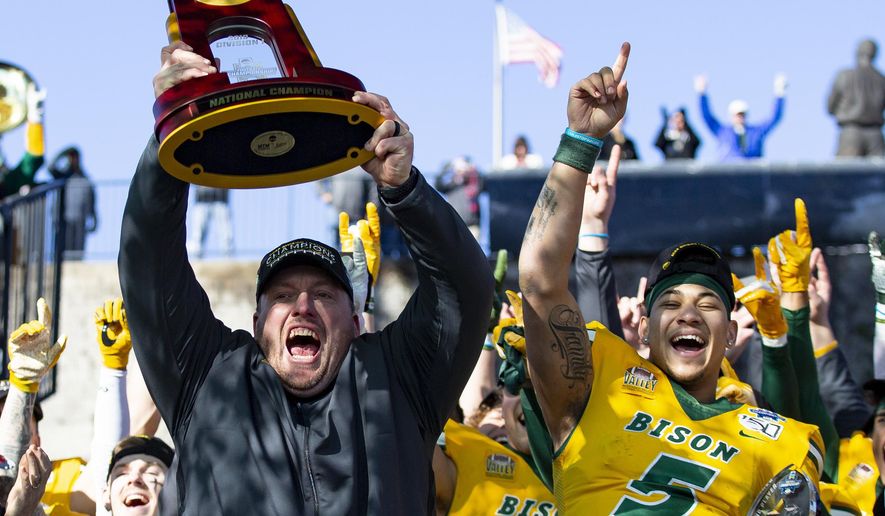 FILE - In this Jan. 11, 2020, file photo, North Dakota State head coach Matt Entz raises the trophy alongside quarterback Trey Lance (5) as they celebrate after beating James Madison 28-20 in the FCS championship NCAA college football game in Frisco, Texas. The Football Championship Subdivision season begins in earnest this weekend. With the fall season and playoffs, some of the top teams could play as many as two dozen games over a calendar year. Health experts say players face immense physical and mental challenges playing so many games.(AP Photo/Sam Hodde, File)