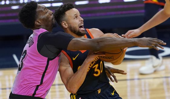 Golden State Warriors guard Stephen Curry, right, is fouled by Miami Heat center Bam Adebayo during the second half of an NBA basketball game in San Francisco, Wednesday, Feb. 17, 2021. (AP Photo/Jeff Chiu)