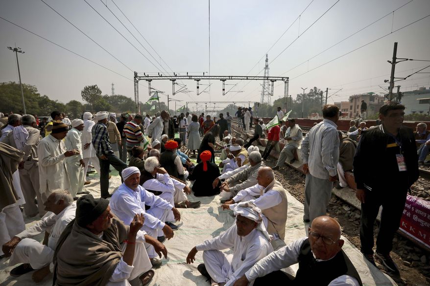 Farmers block a railway track during a protest denouncing three farm laws approved by Parliament in September, which they say will leave them poorer and at the mercy of corporations, in Sonepat, India, Thursday, Feb. 18, 2021. Thousands of protesting farmers blocked trains on Thursday by sitting on railroad tracks in parts of northern India to press their demand for the repeal of new agricultural reform laws that have triggered months of massive protests. (AP Photo/Manish Swarup)