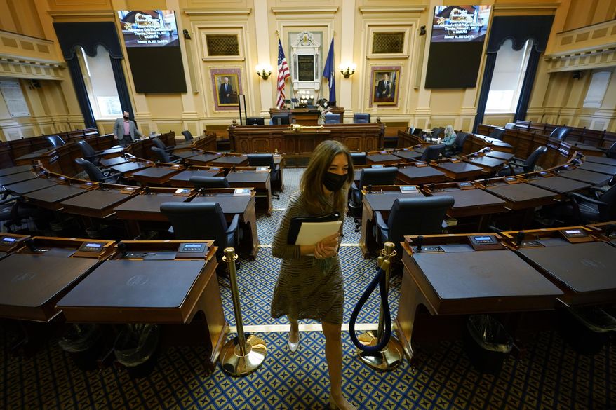 House speaker Del. Eileen Filler-Corn, D-Fairfax, exits the center isle of the empty VirginianHouse of Delegates chamber after a Zoom Legislative session at the Capitol in Richmond, Va., Wednesday, Feb. 10, 2021. (AP Photo/Steve Helber)