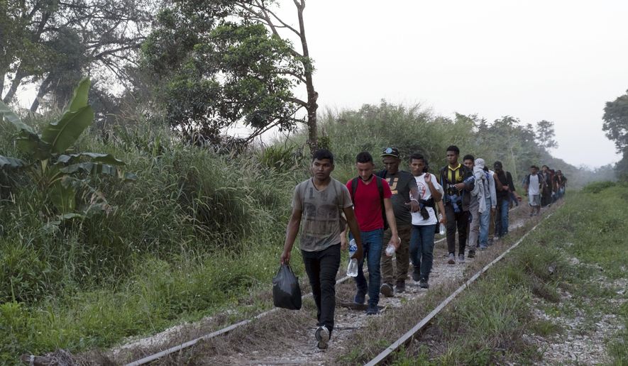 Migrants walk on train tracks on their journey from Central America to the U.S. border., in Palenque, Chiapas state, Mexico, Wednesday, Feb. 10, 2021. (AP Photo/Isabel Mateos)
