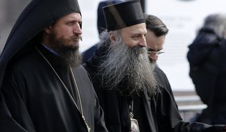 Serbian Orthodox Church bishop Porfirije, centre, leaves the St. Sava temple in Belgrade, Serbia, Thursday, Feb. 18, 2021. Serbian Orthodox Church gathers in closed session to pick a new Patriarch, following the death of old one Irinej. Irinej died last year of covid, following the outbreak of virus among church officials in Belgrade. (AP Photo/Darko Vojinovic)