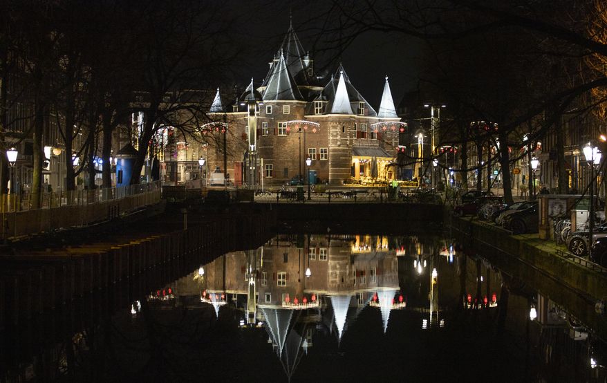 De Waag on Nieuwmarkt Square, historically the eastern gateway to the city, is deserted during curfew in the center of Amsterdam, Saturday, Jan. 23, 2021. The Netherlands entered its toughest phase of anti-coronavirus restrictions to date, imposing a nationwide night-time curfew from 9 p.m. until 4:30 a.m. in a bid to control the COVID-19 infection rate. (AP Photo/Peter Dejong)