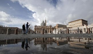 FILE - In this Sunday, Jan. 31, 2021 file photo, people are reflected on a puddle as they walk in St. Peter&#39;s Square, at the Vatican. The Vatican is taking Pope Francis’ pro-vaccine stance very seriously: Any Vatican employee who refuses to get a coronavirus shot without valid medical reason risks being fired.A Feb. 8 decree signed by the governor of the Vatican City State sparked heated debate Thursday, Feb. 18, 2021 since its provisions go well beyond the generally voluntary nature of COVID-19 vaccinations in Italy and much of the rest of the world. (AP Photo/Alessandra Tarantino, File)