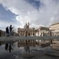In this Sunday, Jan. 31, 2021 file photo, people are reflected on a puddle as they walk in St. Peter&#39;s Square, at the Vatican. The Vatican is taking Pope Francis’ pro-vaccine stance very seriously: Any Vatican employee who refuses to get a coronavirus shot without valid medical reason risks being fired.A Feb. 8 decree signed by the governor of the Vatican City State sparked heated debate Thursday, Feb. 18, 2021 since its provisions go well beyond the generally voluntary nature of COVID-19 vaccinations in Italy and much of the rest of the world. (AP Photo/Alessandra Tarantino, File)
