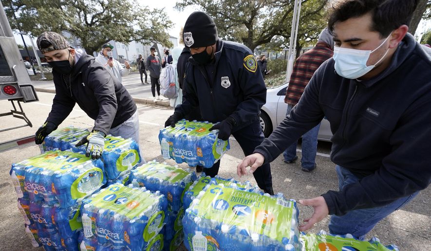 Donated water is distributed to residents, Thursday, Feb. 18, 2021, in Houston. Houston and several surrounding cities are under a boil water notice as many residents are still without running water in their homes. (AP Photo/David J. Phillip)