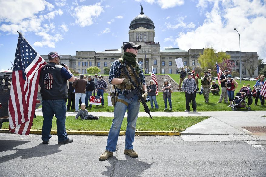 FILE - In this May 20, 2020 file photo protesters gather outside the Montana State Capitol in Helena, Mont. A bill signed into law Thursday, Feb. 19, 2021 by Montana Gov. Greg Gianforte allows concealed firearms to be carried in most places in the state without a permit, and it expands the list of places where guns can be carried to include university campuses and the state Capitol. (Thom Bridge/Independent Record via AP, file)