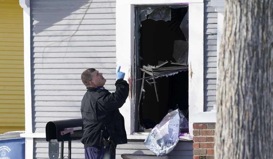 A Dallas police officer investigates a crime scene at a home on the 5300 block of Bonita Ave., where earlier in the day two other officers were shot responding to an emergency call in Dallas, Thursday, Feb. 18, 2021. (AP Photo/Tony Gutierrez)