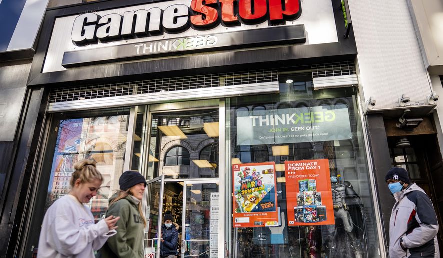 FILE - In this Jan. 28, 2021, file photo, pedestrians pass a GameStop store on 14th Street at Union Square, in the Manhattan borough of New York. The recent GameStop frenzy provided what parents and educators call a teachable moment - an opportunity that presents itself to lend a little insight. The Associated Press talked to a few parents and financial experts for their tips, and included in their advice was teaching kids early on about money, keeping the discussions simple but interesting and letting kids practice investing. (AP Photo/John Minchillo, File)