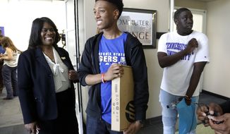 FILE - In this Thursday, May 23, 2019, file photo, Tupac Moseley, center, leaves a news conference with a laptop computer given to him at Tennessee State University with Tennessee State President Dr. Glenda Glover, left, in Nashville, Tenn. Glover, the president of historically Black Tennessee State University has abruptly reversed course on Friday, Feb. 19, 2021, after it was announced she would join the board of private prison operator CoreCivic. In explaining her change of heart on Twitter, Glover, says that she had been interested in joining the Tennessee-based company&#39;s board in order to help “the African American incarcerated population.”  (AP Photo/Mark Humphrey, File)