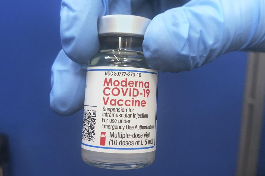 A vial of Moderna COVID-19 vaccine is held at a vaccination site Friday, Feb. 19, 2021, in Oklahoma City. (AP Photo/Sue Ogrocki)