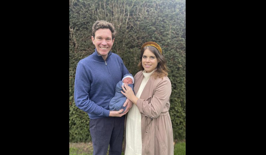 In this undated photo released by Buckingham Palace on Saturday, Feb. 20, 2021, Britain&#39;s Princess Eugenie and  her husband, Jack Brooksbank pose for a photo with their son. The couple have named their baby August Philip Hawke Brooksbank, Buckingham Palace said Saturday. The baby — a ninth great-grandchild for Queen Elizabeth II — was born Feb. 9 at London’s Portland Hospital. (Princess Eugenie and Jack Brooksbank via AP)
