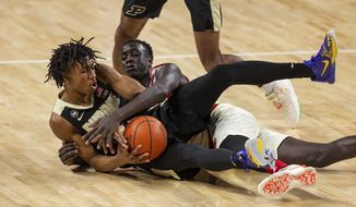 Purdue guard Jaden Ivey (23) and Nebraska forward Lat Mayen (11) fight for the ball in the first half during an NCAA college basketball game Saturday, Feb. 20, 2021, in Lincoln, Neb. (AP Photo/John Peterson)