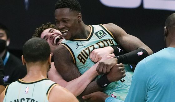 Charlotte Hornets guard Terry Rozier celebrates after scoring the game winning basket with LaMelo Ball, left, against the Golden State Warriors during an NBA basketball game on Saturday, Feb. 20, 2021, in Charlotte, N.C. (AP Photo/Chris Carlson)
