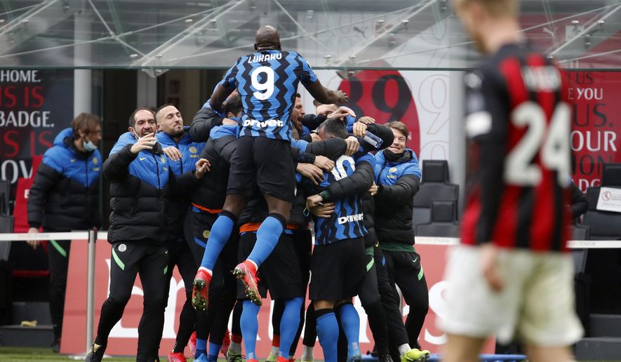 Inter players celebrate after Lautaro Martinez scored his side&#x27;s second goal, during the Serie A soccer match between AC Milan and Inter Milan, at the Milan San Siro Stadium, Italy, Sunday, Feb. 21, 2021. (AP Photo/Antonio Calanni)