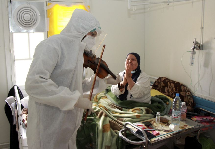 Dr. Mohamed Salah Siala plays the violin for patients on the COVID wards of the Hedi Chaker hospital in Sfax, eastern Tunisia, Saturday Feb. 20, 2021. When the 25-year-old decided to get out his violin one day at Hedi Chaker Hospital in city of Sfax and play, it won praise for boosting the morale of virus sufferers who remained isolated and needed a smile. (AP Photo)