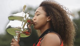 Japan&#39;s Naomi Osaka kisses the Daphne Akhurst Memorial Cup during a photo shoot at Government House the day after defeating United States Jennifer Brady in the women&#39;s singles final at the Australian Open tennis championship in Melbourne, Australia, Sunday, Feb. 21, 2021.(AP Photo/Hamish Blair)