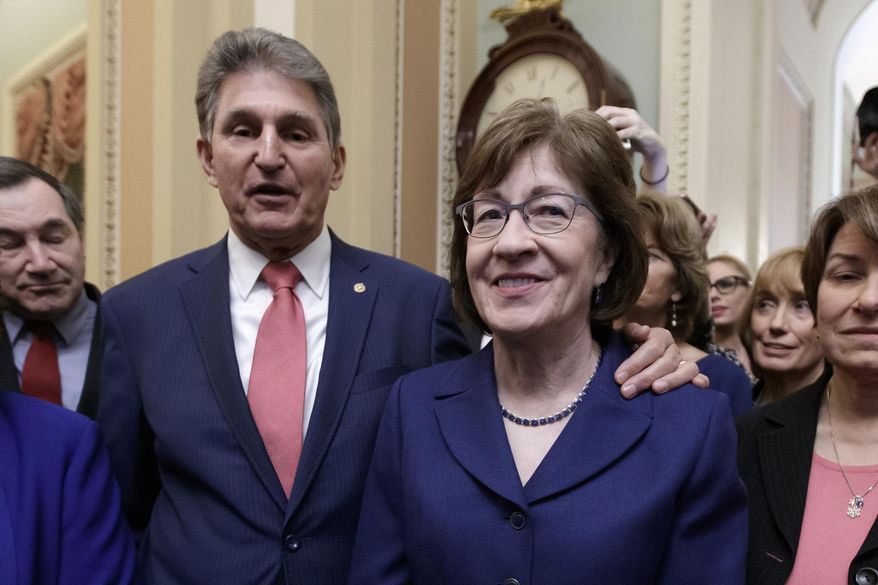 In this file photo from Monday, Jan. 22, 2018, Sen. Susan Collins, R-Maine, is joined by then-Sen. Joe Manchin, D-W.Va., left, and others as they celebrate the bipartisan effort to end a government shutdown, at the Capitol in Washington. (AP Photo/J. Scott Applewhite, File)