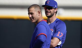 Chicago Cubs&#39; Anthony Rizzo, left, and Kris Bryant stand on the field during a spring training baseball workout in Mesa, Ariz., Monday, Feb. 22, 2021. (AP Photo/Jae C. Hong)