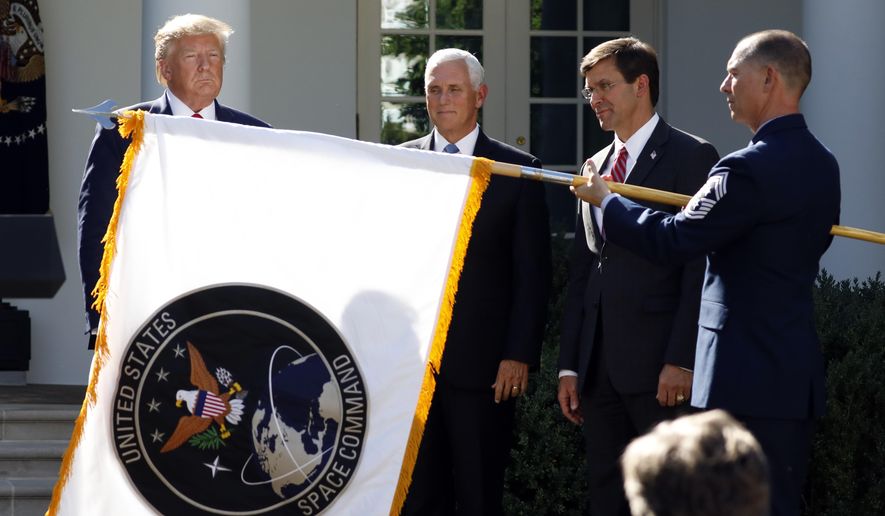 In this Aug. 29, 2019, photo, President Donald Trump, left, watches with Vice President Mike Pence and Defense Secretary Mark Esper as the flag for U.S. Space Command is unfurled as Trump announces the establishment of the U.S. Space Command in the Rose Garden of the White House in Washington. (AP Photo/Carolyn Kaster) **FILE**