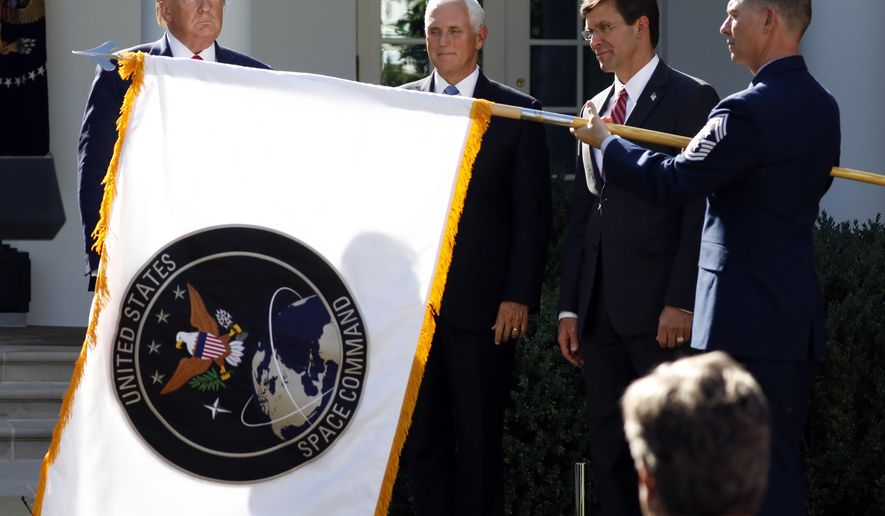 In this Aug. 29, 2019, photo, then-President Donald Trump, left, watches with then-Vice President Mike Pence and former Defense Secretary Mark Esper as the flag for U.S. Space Command is unfurled as Trump announces the establishment of the U.S. Space Command in the Rose Garden of the White House in Washington. (AP Photo/Carolyn Kaster) **FILE**