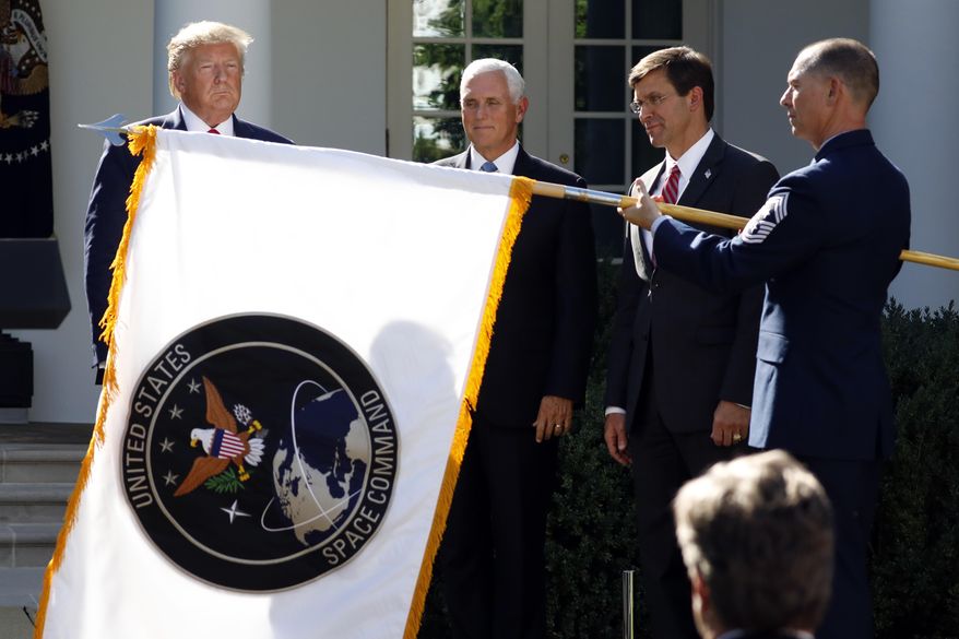 In this Aug. 29, 2019, photo, President Donald Trump, left, watches with Vice President Mike Pence and Defense Secretary Mark Esper as the flag for U.S. Space Command is unfurled as Trump announces the establishment of the U.S. Space Command in the Rose Garden of the White House in Washington. (AP Photo/Carolyn Kaster) **FILE**