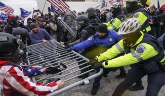 In this Jan. 6, 2021, photo, rioters try to break through a police barrier at the Capitol in Washington. (AP Photo/John Minchillo) **FILE**