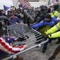 In this Jan. 6, 2021, photo, rioters try to break through a police barrier at the Capitol in Washington. (AP Photo/John Minchillo) **FILE**