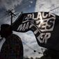In this Dec. 12, 2020, file photo, MD Crawford carries a Black Lives Matter flag before a march in La Marque, Texas to protest the shooting of Joshua Feast, 22, by a La Marque police officer.  (Stuart Villanueva /The Galveston County Daily News via AP, File)  **FILE**