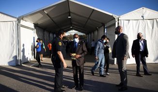 Houston Police Department Chief Art Acevedo and Houston Mayor Sylvester Turner talk by the new federally-supported and state-managed COVID-19 vaccination clinic tents at NRG Park, Monday, Feb. 22, 2021, in Houston. (Marie D. De Jesus/Houston Chronicle via AP)
