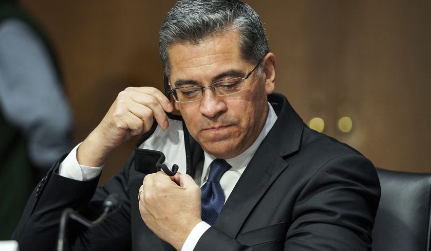 Xavier Becerra removes his mask to make an opening statement during a Senate Finance Committee hearing on his nomination to be secretary of Health and Human Services on Capitol Hill in Washington, Wednesday, Feb. 24, 2021. (Greg Nash/Pool via AP)