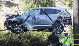 A crane is used to lift a vehicle following a rollover accident involving golfer Tiger Woods, Tuesday, Feb. 23, 2021, in the Rancho Palos Verdes suburb of Los Angeles. Woods suffered leg injuries in the one-car accident and was undergoing surgery, authorities and his manager said. (AP Photo/Ringo H.W. Chiu) **FILE**