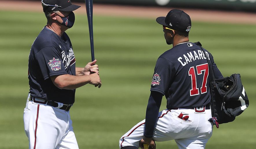 Atlanta Braves Hall of Famer Chipper Jones, left, gives infielder Johan Camargo some batting tips during spring baseball training Tuesday, Feb. 23, 2021, in North Port, Fla. (Curtis Compton/Atlanta Journal-Constitution via AP)
