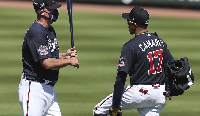 Atlanta Braves Hall of Famer Chipper Jones, left, gives infielder Johan Camargo some batting tips during spring baseball training Tuesday, Feb. 23, 2021, in North Port, Fla. (Curtis Compton/Atlanta Journal-Constitution via AP)