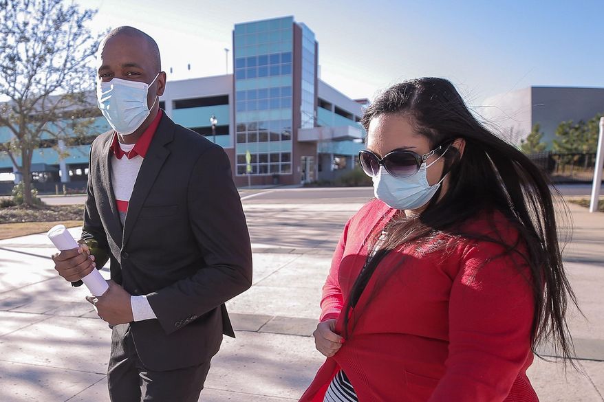 Moss Point Mayor Mario King, left, and his wife, Natasha King, head toward the federal courthouse in Gulfport, Miss., Wednesday, Feb. 24, 2021, to plead guilty to a charge of conspiring to defraud the federal government. Prosecutors said the mayor, who resigned Wednesday, and his wife had raised money for mental health programs in schools but spent it on themselves for expenses that included car payments and the purchase of a pet dog. (Alyssa Newton/The Sun Herald via AP)