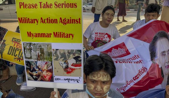 An anti-coup protester holds a placard requesting military action against Myanmar military in Yangon, Myanmar Thursday, Feb. 25, 2021. Protesters against the military&#39;s seizure of power in Myanmar were back on the streets of cities and towns on Thursday as regional diplomatic efforts to resolve Myanmar&#39;s political crisis intensified Wednesday. (AP Photo)