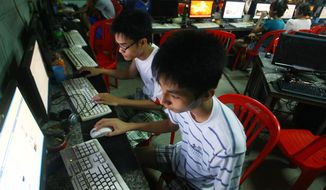 In this Sept. 27, 2012, file photo, two students use computers at an internet cafe near their dormitory in Hanoi, Vietnam. Amnesty International has found that a hacking group known as Ocean Lotus has been staging more spyware attacks on Vietnamese human rights activists in the latest blow to freedom of speech in the communist-ruled country. AP Photo/Na Son Nguyen, File)
